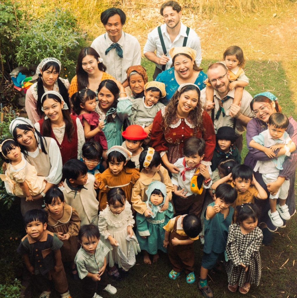 A family enjoying a campfire night at Firefly Forest School’s family-friendly summer camp in Bangkok.

