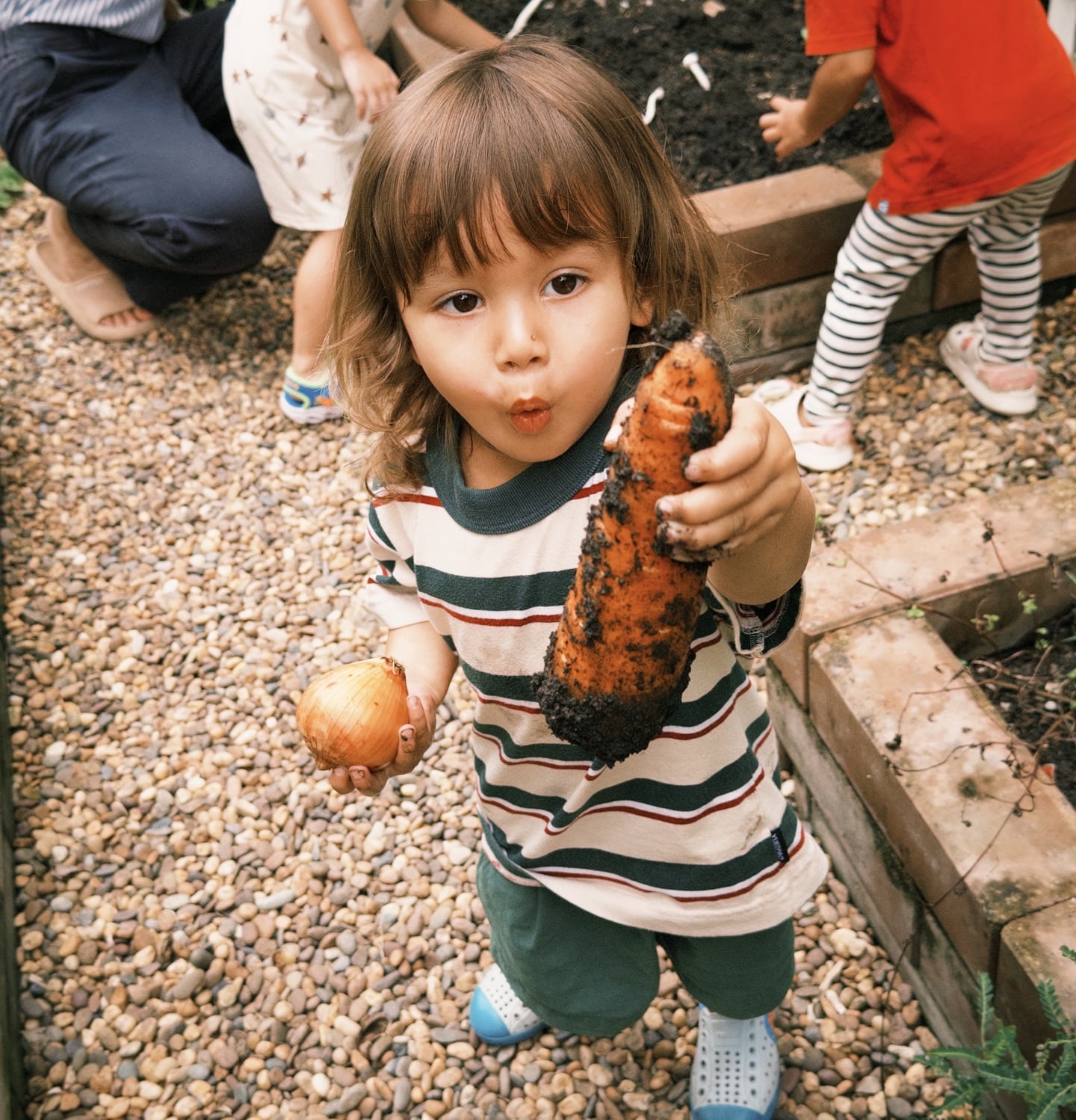 Children exploring a corn during a nature-based summer program at Firefly Forest School in Bangkok.