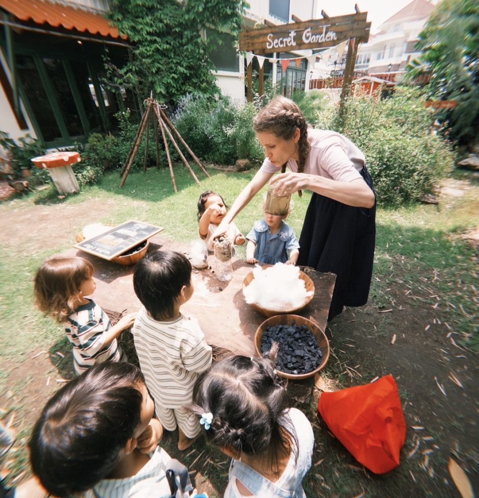 Children exploring the Secret Garden during a playgroup at Firefly Forest School in Bangkok.


