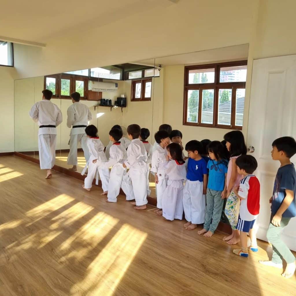 Children practicing karate moves in the school during a class at Firefly Forest School in Bangkok