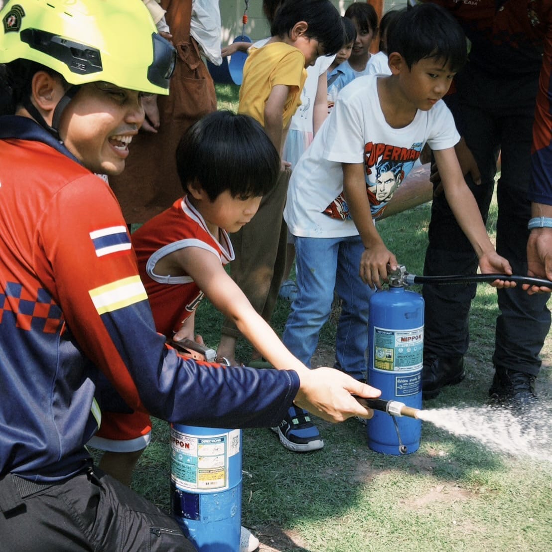 A teacher guiding a small group of children in the Secret Garden at Firefly Forest School in Bangkok.