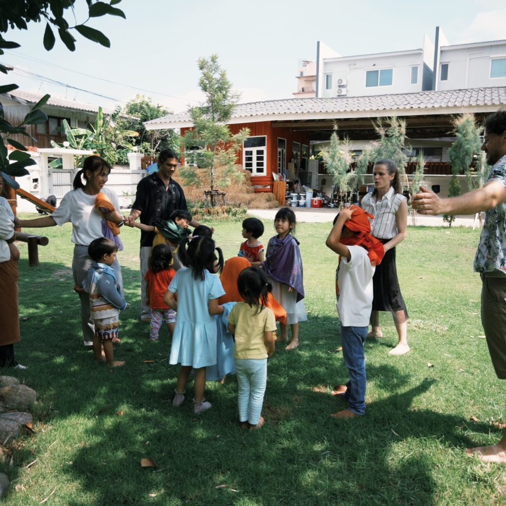 A group of kids playing under the trees at Firefly Forest School’s Waldorf-inspired school in Bangkok.

