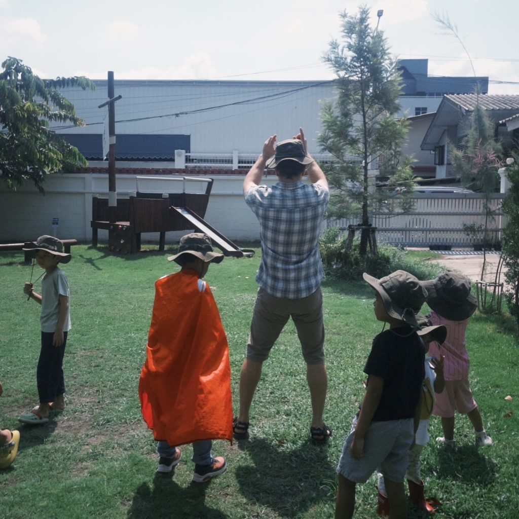 A group of kids setting up a tent at Firefly Forest School’s summer program in Bangkok.

