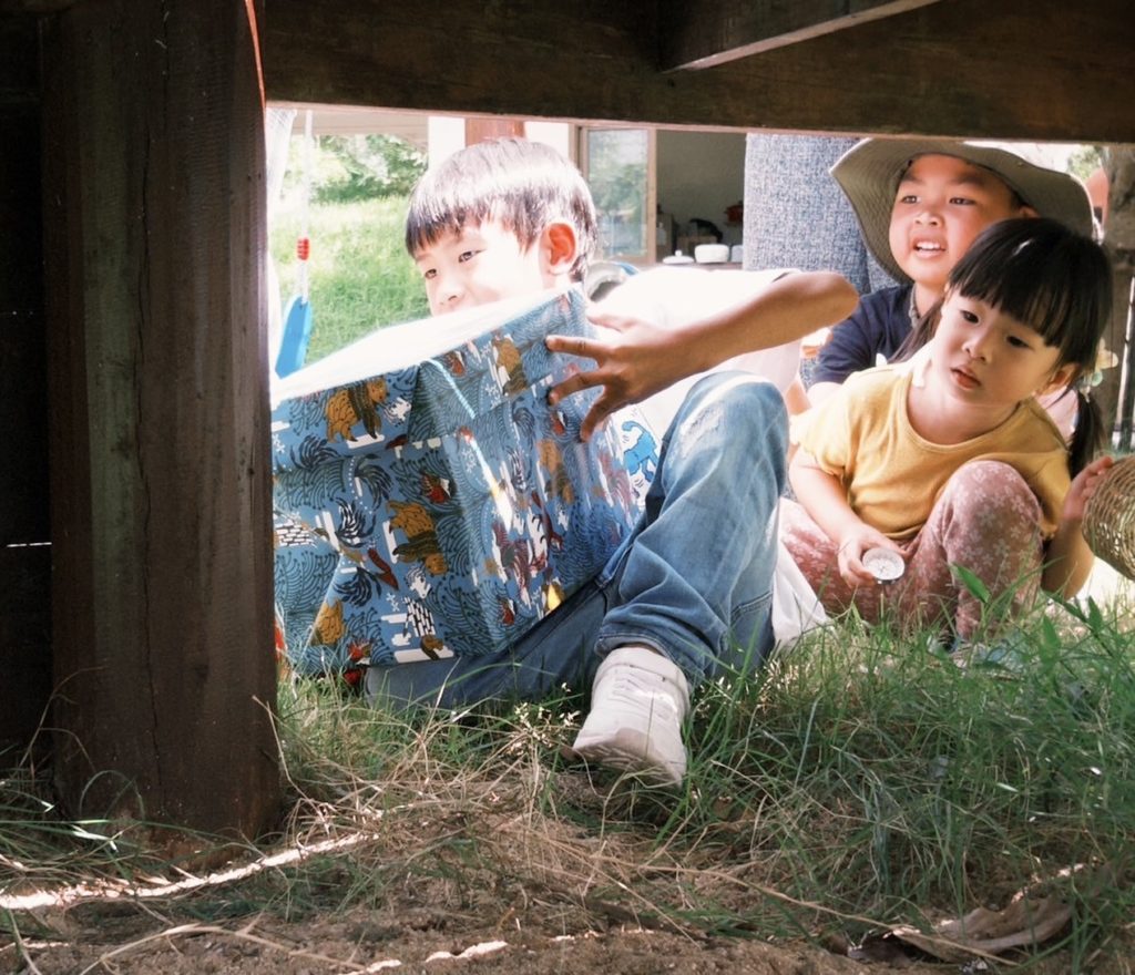 A group of kids on a scavenger hunt during a forest school activity at Firefly Forest School in Bangkok.

