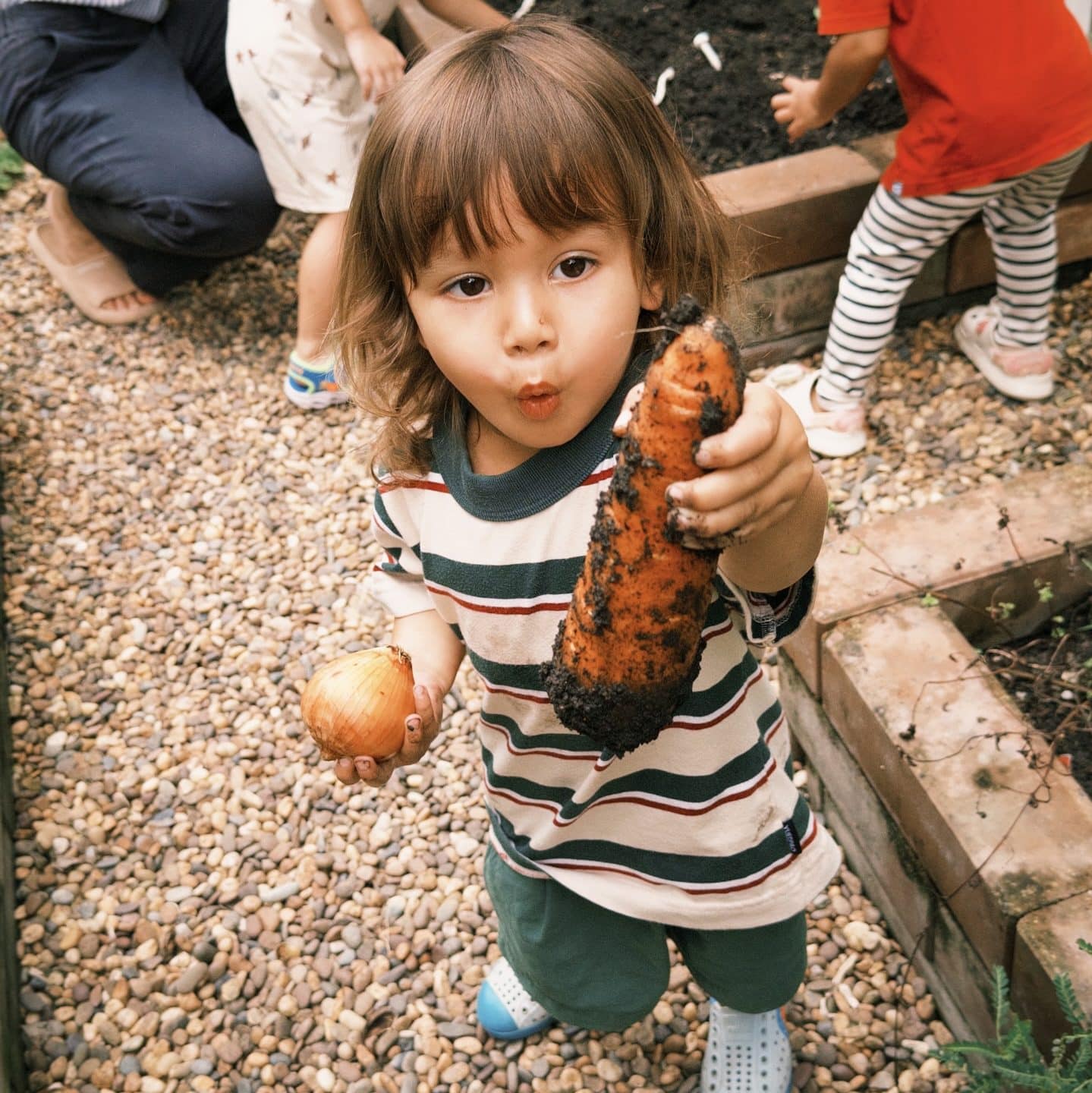 Children exploring a corn during a nature-based summer program at Firefly Forest School in Bangkok.