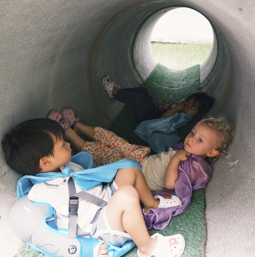 "A group of children exploring tunnels during  play at Firefly Forest School’s nature-based preschool in Bangkok.

