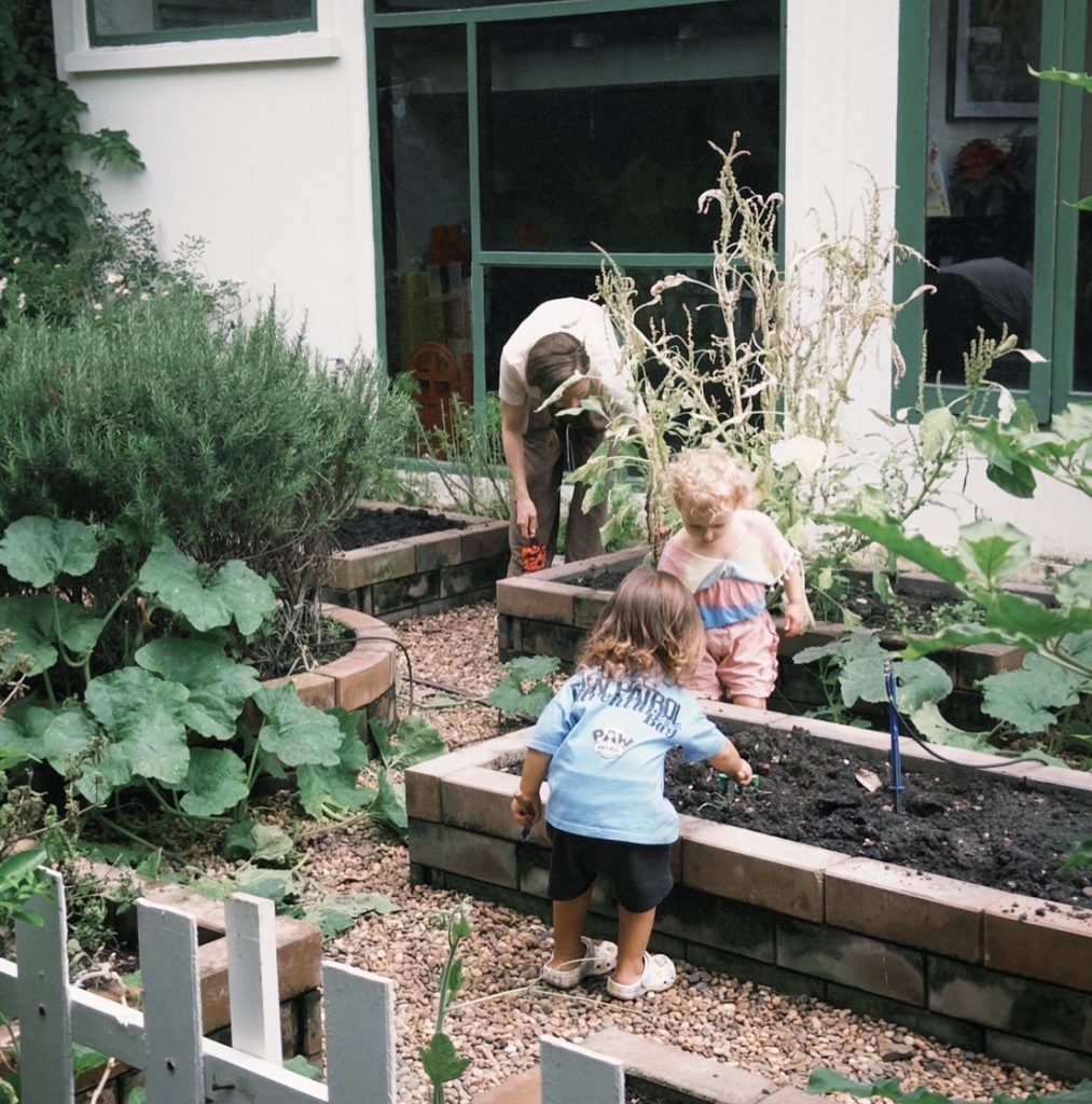 Children observing flowers during a nature study session at Firefly Forest School in Bangkok.