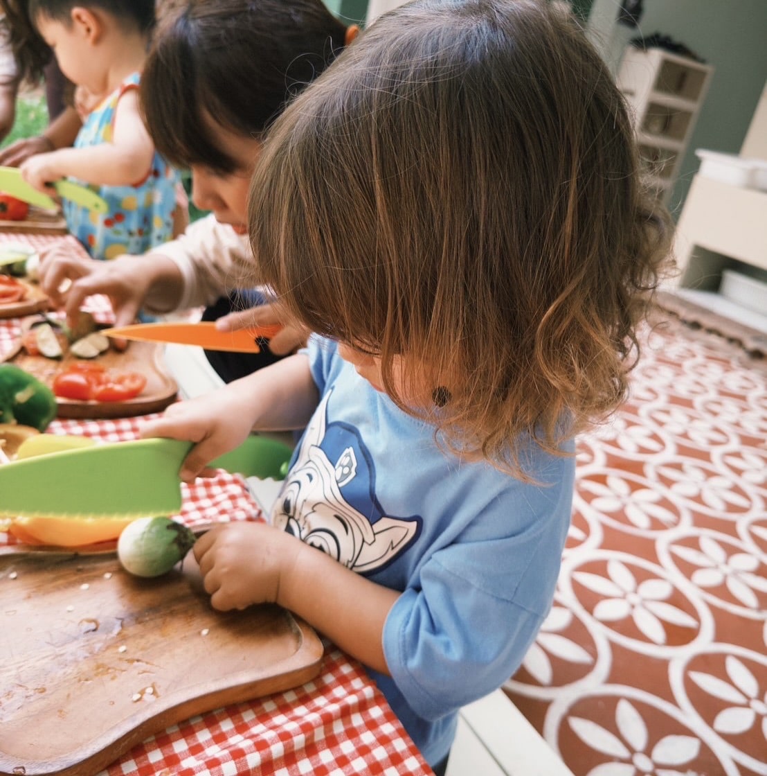 Children painting rocks they found during a child-led learning session at Firefly Forest School in Bangkok.