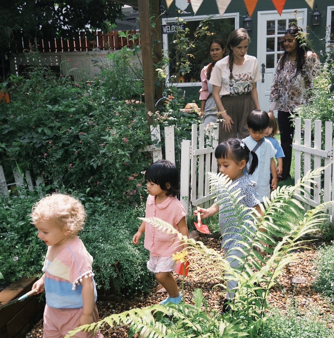 "Toddlers exploring the Secret Garden at Firefly Forest School during a nature-based preschool activity in Bangkok."