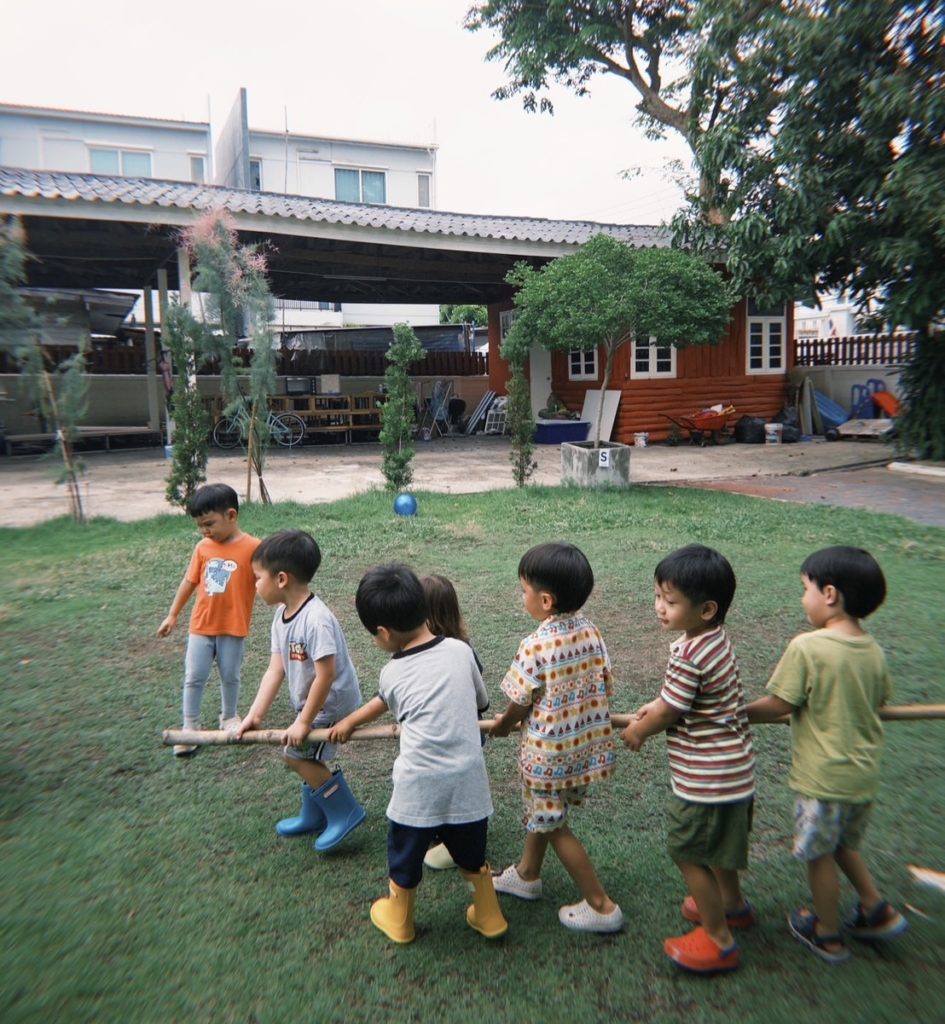 A group of kids on a scavenger hunt during forest play at Firefly Forest School in Bangkok.

