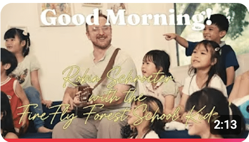 FireFly Forest School children singing and smiling during Circle Time for the Good Morning song